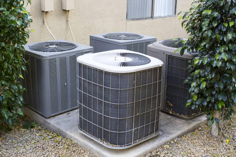 Residential air conditioner compressor units near building